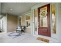 Inviting front porch featuring a decorative wreath and chair, creating a warm welcome to the home at 12811 Elkhorn Dr, Charlotte, NC 28278