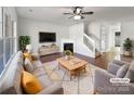 Bright living room boasts a fireplace, ceiling fan, and neutral décor, virtually staged for inspiration at 13510 Tranters Creek Ln, Charlotte, NC 28273
