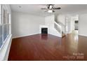 An empty living room featuring hardwood floors, a fireplace and staircase at 13510 Tranters Creek Ln, Charlotte, NC 28273