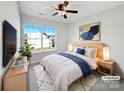 Stylish primary bedroom featuring a large window, ceiling fan, and tastefully curated decor at 13510 Tranters Creek Ln, Charlotte, NC 28273