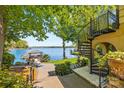 Backyard featuring a spiral staircase, patio, landscaped yard and a private dock on the calm lake at 16 Sunrise Point Ct, Lake Wylie, SC 29710