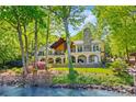 Beautiful lakefront home with stone chimney, second story balcony, landscaped front lawn, and scenic lake views at 16 Sunrise Point Ct, Lake Wylie, SC 29710