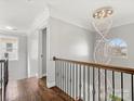 Elegant hallway featuring a stunning chandelier and hardwood floors at 2100 Bluebonnet Ln, Matthews, NC 28104