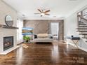 Bright living room features a modern fireplace, wood flooring, and large windows at 2100 Bluebonnet Ln, Matthews, NC 28104