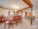 Spacious dining room featuring wood beam accents with easy access to the living room with fireplace at 2615 High Ridge Church Rd, Marshville, NC 28103