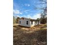 Single-story home with gray siding and natural landscaping, offering a serene and private setting at 3437 Wilkesboro Hwy, Statesville, NC 28625