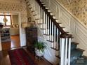 Elegant staircase with wainscoting and a view into the adjacent kitchen at 511 Glencurry Dr, Charlotte, NC 28214