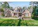 Beautiful two-story brick home featuring manicured lawn, dormers, and mature trees at 5601 Turkey Oak Dr, Mint Hill, NC 28227