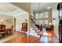 Grand foyer showcasing hardwood floors, staircase, soaring ceilings, and adjacent dining room at 5601 Turkey Oak Dr, Mint Hill, NC 28227