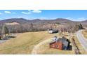 Aerial view of a brick home with expansive lawn, complemented by picturesque mountain views at 6231 Nc 16 N Hwy, Taylorsville, NC 28681
