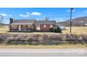 Inviting brick home featuring a well-maintained lawn and a classic, comfortable aesthetic at 6231 Nc 16 N Hwy, Taylorsville, NC 28681