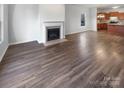 Unfurnished living room with a fireplace and wood floors flowing into the kitchen at 7231 Waldon Park Ln, Charlotte, NC 28214