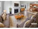 Staged living room with a fireplace, hardwood floors, a cozy sofa, and decor throughout an open floorplan at 7231 Waldon Park Ln, Charlotte, NC 28214