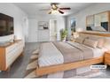 Staged main bedroom with a modern bed, ceiling fan, and a view of the attached bathroom at 7231 Waldon Park Ln, Charlotte, NC 28214