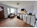Sunlit living room with a decorative brick fireplace and hardwood flooring, staged with potential design elements at 930 Weaver Rd, China Grove, NC 28023