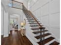 Grand staircase with dark wood steps and wrought iron railing, complemented by light walls and hardwood flooring at 13500 Robert Walker Dr, Davidson, NC 28036