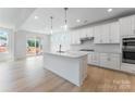 Modern white kitchen features an island with pendant lighting and stainless steel appliances at 136 Glenn Dr, Mooresville, NC 28115