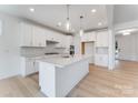 Bright kitchen featuring white cabinets, quartz countertops, stainless steel appliances, and pendant lights at 136 Glenn Dr, Mooresville, NC 28115
