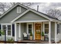 View of the home's front porch with wooden door and charming decorations at 1532 South Point Rd, Belmont, NC 28012