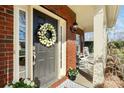 Welcoming front door with a decorative wreath, sidelights, and charming porch seating at 2000 Willowcrest Dr, Waxhaw, NC 28173