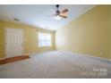 Bright and airy living room with carpeted floors, a ceiling fan, and a view of the front door at 2007 Wexford Way, Statesville, NC 28625