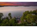 Breathtaking aerial view of lakefront home with private dock surrounded by lush trees at 21013 Island Forest Dr, Cornelius, NC 28031