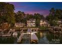Beautiful backyard with a dock and boat lift on a tranquil lake at twilight at 21013 Island Forest Dr, Cornelius, NC 28031