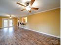 Open living room featuring hardwood flooring, ceiling fan, and a view of the kitchen through a pass-through window at 211 9Th St, Belmont, NC 28012