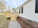 The exterior of the home includes a nice-sized wooden deck and white vinyl siding with black shutters at 288 John L Hudson Sr Rd, Lancaster, SC 29720