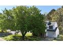 Two-story home featuring a green lawn and mature shade tree in a suburban setting at 303 Cupped Oak Ct, Charlotte, NC 28213