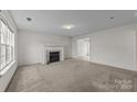 Living room with a fireplace, light colored carpet, and large window at 303 Cupped Oak Ct, Charlotte, NC 28213