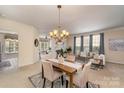 Bright dining room adjacent to the living room, featuring an elegant chandelier and neutral tones at 418 Garnet Ct, Fort Mill, SC 29708
