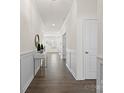 Elegant hallway with dark wood floors, white wainscoting, and ample natural light at 491 Creevy Nw Dr, Concord, NC 28027