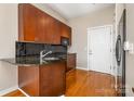Kitchen featuring granite countertops, wooden cabinets, and hardwood floors at 525 E Sixth St # 208, Charlotte, NC 28202