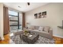 Living room featuring hardwood floors, neutral decor, a large window, and modern furnishings at 525 E Sixth St # 208, Charlotte, NC 28202