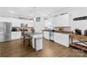 Bright kitchen features white cabinetry, stainless steel appliances, granite counters, and a functional center island at 5405 Austin Rd, Monroe, NC 28112