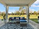 Inviting covered patio with comfortable seating, stylish decor, and a view of the landscaped backyard at 5585 Zeeland Ln, Fort Mill, SC 29707