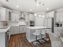 Bright kitchen featuring stainless appliances, an island with bar seating, and white cabinets at 5585 Zeeland Ln, Fort Mill, SC 29707