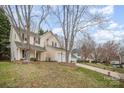 Two-story home with landscaped yard, driveway, and mature trees on a sunny day at 6027 Edinmeadow Ln # 29, Charlotte, NC 28269