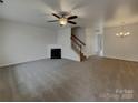 Spacious carpeted living room features a fireplace, ceiling fan and neutral color palette at 725 Rock Lake Gln, Fort Mill, SC 29715