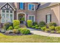 Charming home featuring manicured bushes lining the walkway to the front door at 805 Hidden Pond Ln, Waxhaw, NC 28173