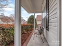 Covered front porch featuring seating and a brick lined border with well maintained shrubs at 841 Platinum Dr, Fort Mill, SC 29708
