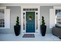 Stylish front door featuring a wreath, potted topiaries, and decorative accents at 875 Stratford Run Dr, Fort Mill, SC 29708