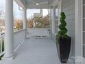 Relaxing front porch with a swing, white railings, and a decorative green plant at 875 Stratford Run Dr, Fort Mill, SC 29708