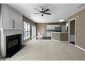 Open-plan living room featuring a fireplace, ceiling fan, and connection to kitchen at 9139 Hearst Ct, Charlotte, NC 28269