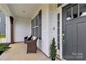 Cozy front porch featuring wicker chairs and a view of the home's modern exterior and entryway at 2408 Napa Ter, Clover, SC 29710