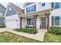 Inviting front porch with dark wood columns and two wicker chairs in front of a modern white home at 2408 Napa Ter, Clover, SC 29710