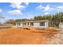 Inviting single-story house features a cozy porch and a lush, expansive yard perfect for relaxation and outdoor enjoyment at 255 Liberty Estates Ln, Taylorsville, NC 28681