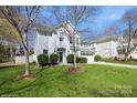 Charming two-story home featuring a well-manicured lawn, mature trees, and a classic white facade at 6816 Charter Hills Rd, Charlotte, NC 28277