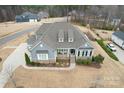 Aerial view of home featuring gray siding, manicured lawn, and three-car garage at 107 Hillside Cove Ct, Mooresville, NC 28117